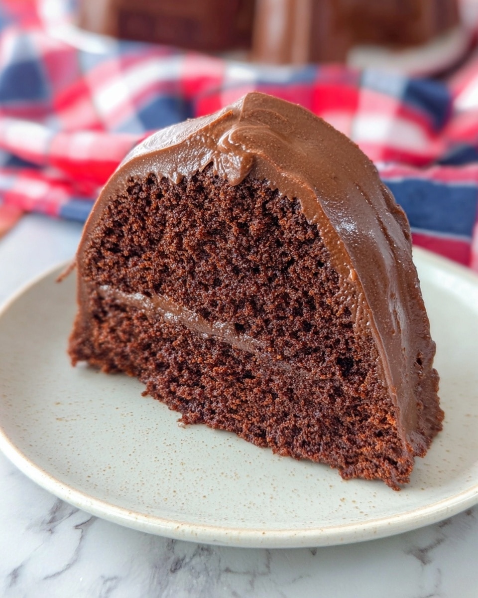 A chocolate bundt cake sits on a white plate with scalloped edges, placed on a white marbled texture with a red, white, and blue checkered cloth nearby. The cake has one main layer of dark brown, moist cake, and it is topped with a thick drizzle of glossy milk chocolate glaze that flows unevenly over the top and down the sides, creating a shiny texture that contrasts with the matte cake. The glaze pools slightly in the ring center and at the bottom edge. Photo taken with an iphone --ar 4:5 --v 7