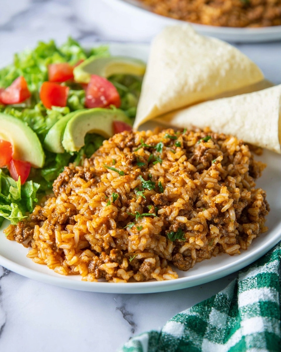 The image shows a close-up of a cooked dish in a black pan with one layer of soft brown ground beef mixed thoroughly with white cooked rice, coated in a reddish-orange sauce that makes the texture look creamy and moist. Bright green parsley leaves are scattered on top, adding pops of fresh color contrasting with the warm colors of the beef and rice. A silver spoon is scooping up a portion from the pan, showing the mix of ingredients with some rice grains clearly visible. The pan is placed on a white marbled surface. Photo taken with an iphone --ar 4:5 --v 7