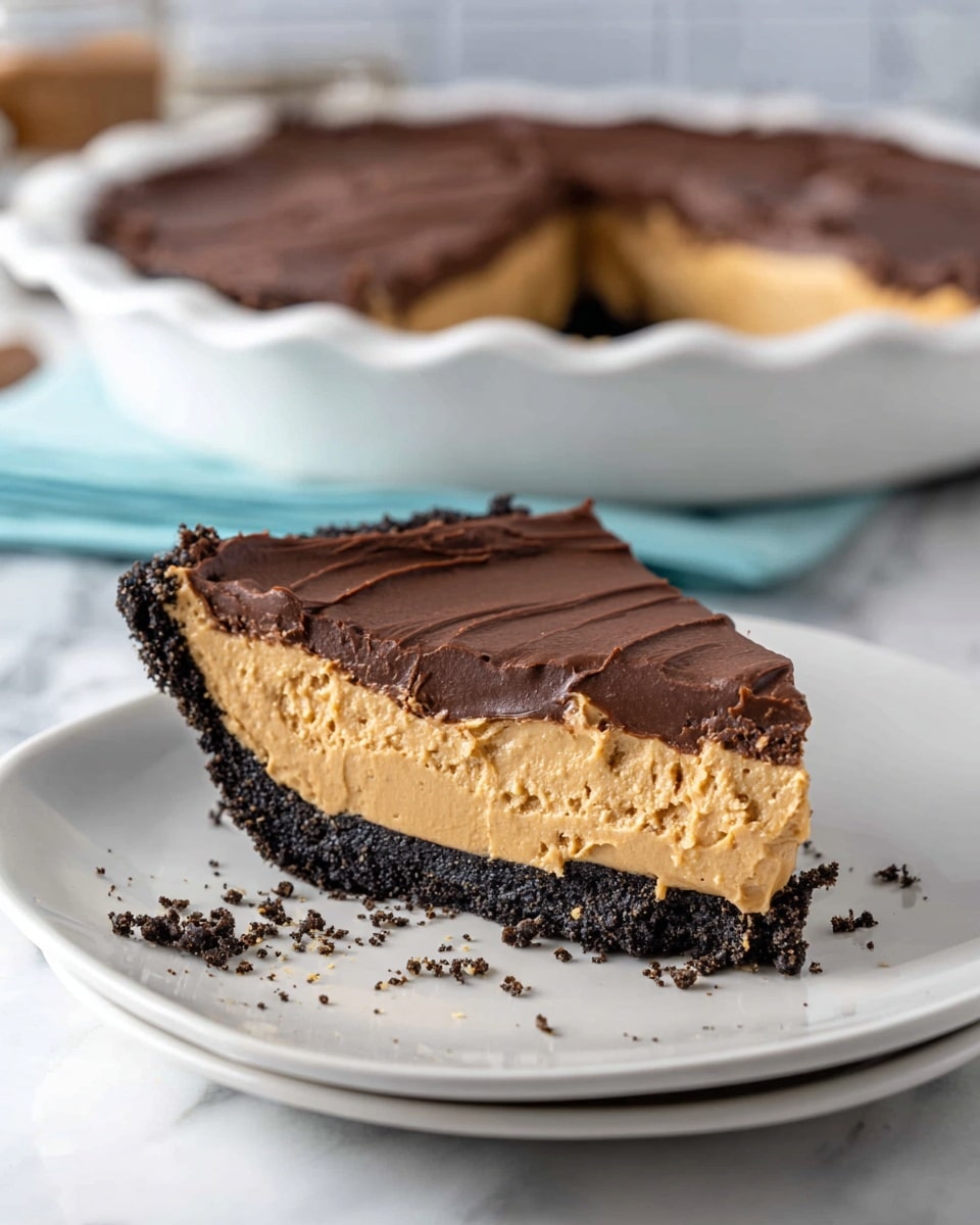 A slice of pie is shown on a white plate with a white marbled texture surface. The pie has three main layers: the bottom is a dark, crumbly crust, the middle is a thick, creamy layer in light peanut butter color with a smooth texture, and the top is a thick, rich chocolate layer with a slightly wavy, textured surface. There are some crumbs around the slice on the plate. In the background, there is a white pie dish with rest of the pie, topped with the same smooth chocolate layer. Photo taken with an iphone --ar 4:5 --v 7