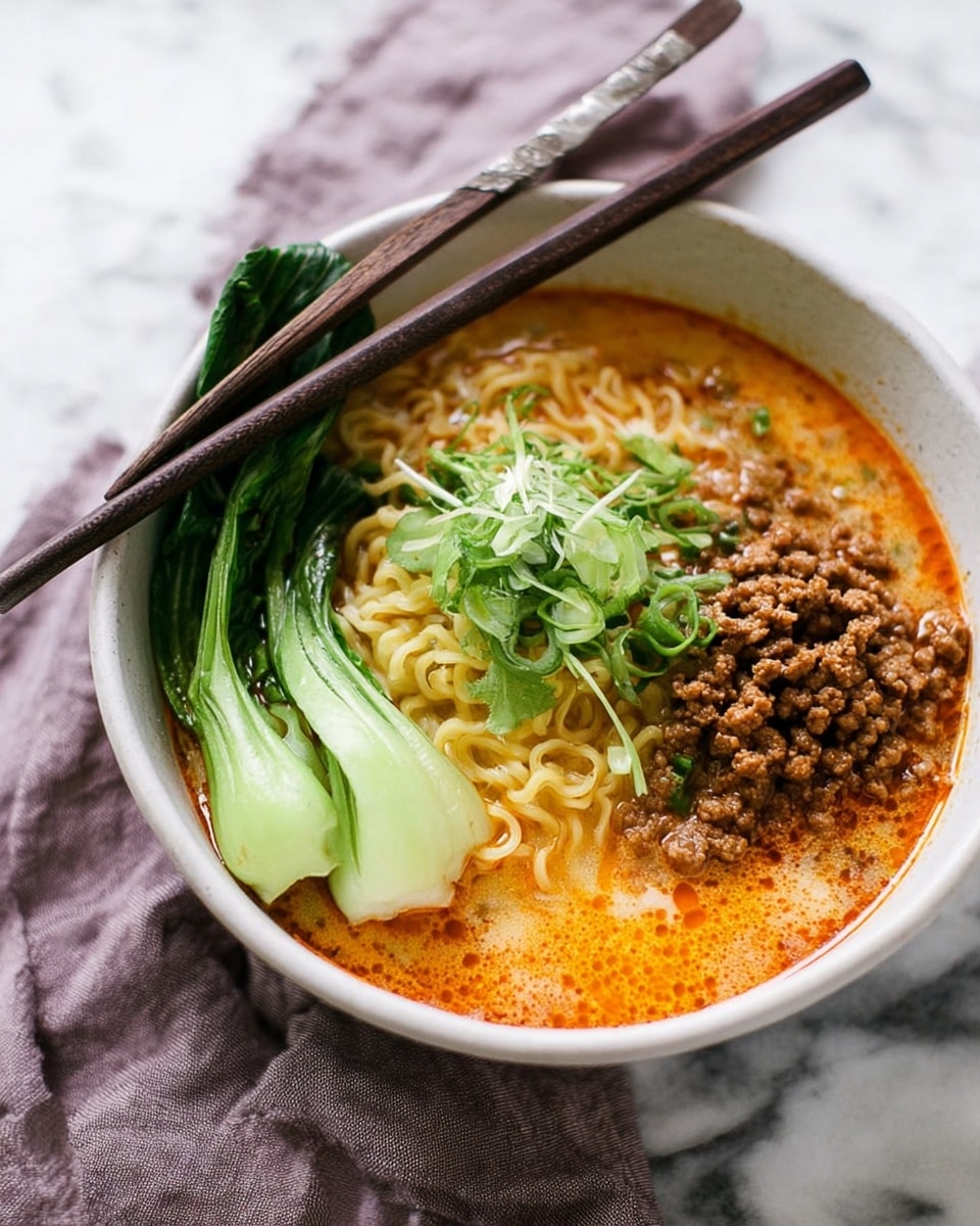 A white bowl filled with a rich creamy broth that has an orange oil swirl on the surface, holding a nest of yellow noodles in the center. On one side, there is a pile of brown cooked ground meat, and on the other, a bright green piece of bok choy with a few sliced light green scallions and fresh green sprouts on top. A pair of dark wooden chopsticks rests on the edge of the bowl, positioned inside the broth, and a soft purple cloth lies beside the bowl on a white marbled surface. Photo taken with an iphone --ar 4:5 --v 7