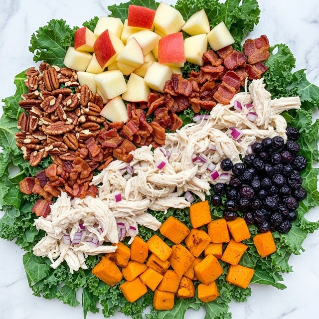 The dish shows several layers starting with a base of green leafy kale covering the bottom. On top of the kale, there is shredded white chicken mixed with small bits of red onion, placed mostly in the center and stretching towards the sides. Alongside the chicken, there are pieces of crispy, dark brown bacon scattered mainly on the top right and center left areas. Above the kale and bacon, chunks of red-skinned apple slices with white flesh are arranged near the top. At the bottom right, there are bright orange roasted pumpkin cubes, complementing a cluster of deep purple dried blueberries nearby. At the top left corner, there are crunchy pecans adding a different texture to the mix. All ingredients rest on a white marbled background. photo taken with an iphone --ar 4:5 --v 7