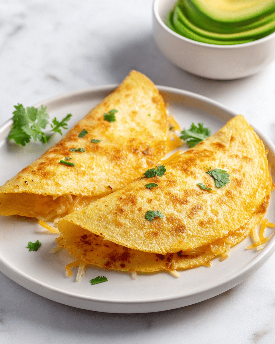 Two folded golden-yellow tortillas with a slightly crispy outside are placed side by side on a round white plate, showing some melted cheese and shredded texture peeking from one side. Small green cilantro leaves are scattered on the tortillas and the plate, adding a touch of color. Behind the plate, a white bowl contains several slices of bright green avocado, standing upright. The whole scene is set on a white marbled surface, with soft natural light giving a fresh and appetizing look. photo taken with an iphone --ar 4:5 --v 7