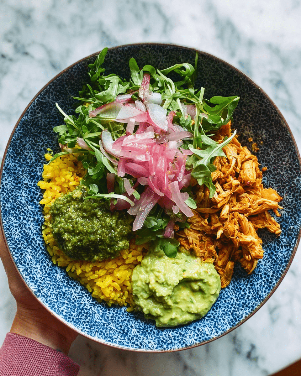 A patterned white bowl holds a colorful layered dish. The bottom layer is yellow rice, placed mostly on one side. Above the rice sits a thick green sauce with a coarse texture. Next to the sauce is shredded chicken coated in a reddish-brown sauce. On the opposite side, fresh green leafy vegetables and arugula form a loose, textured bed. Thin slices of purple and white onions are piled lightly on top of the greens. Scattered radish pieces with red edges and white centers add contrast. A woman's hand holding the bowl is visible at the bottom left. The background is a white marbled texture. photo taken with an iphone --ar 4:5 --v 7